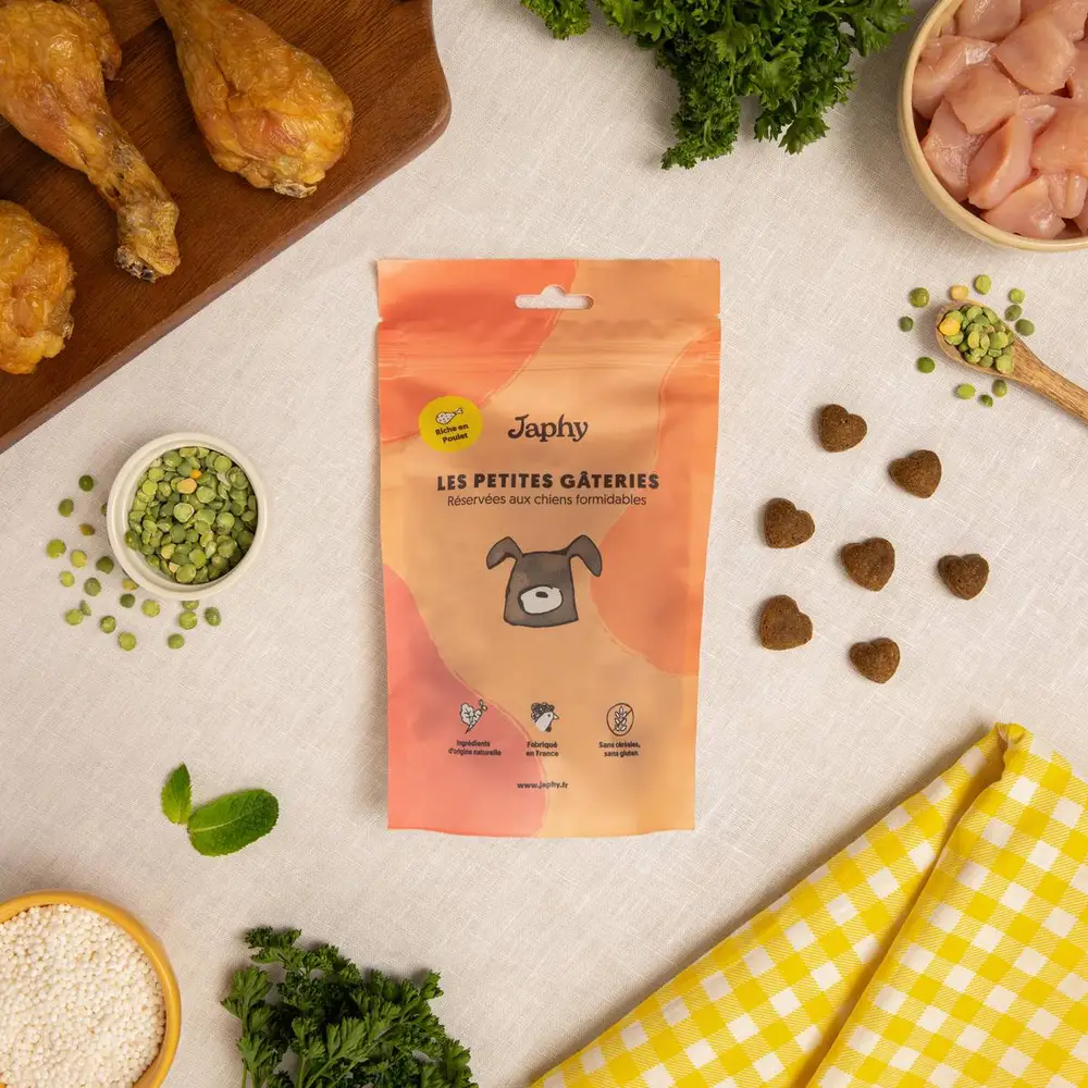 Sachet de friandises Japhy riche en poulet, entouré des ingrédients mis en avant par la marque : poulet, pois cassés et persil